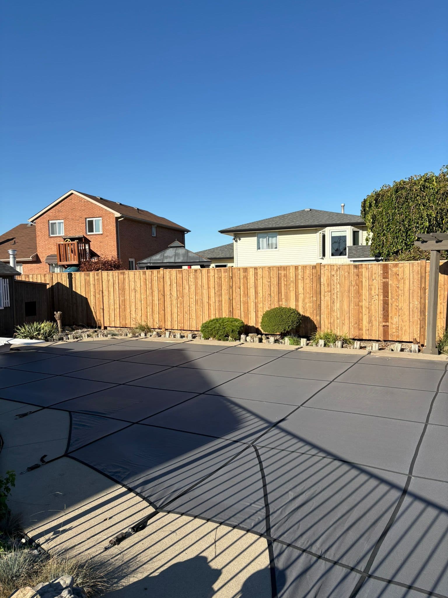 Pristine residential wood fence in front yard with landscaping